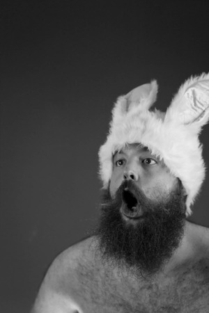 Amazed bearded fat man wears silly bunny earsの写真素材