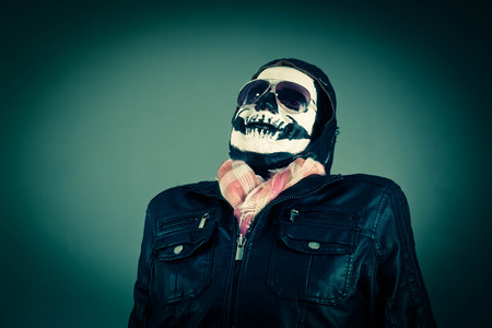 Scared Disapproving aviator with face painted as human skullの写真素材
