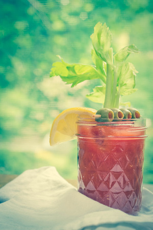 Bloody Mary vodka cocktail made at home sitting on counter by windowの写真素材