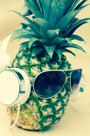 Cool pineapple with sunglasses and headphones in summer themed photoの写真素材