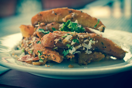 Spicy fried Indian potato wedges with coriander and coconut shavingsの写真素材