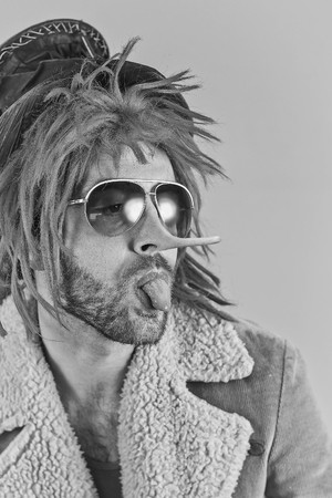 Lying pink haired bearded bum lunatic man with cool sunglassesの写真素材