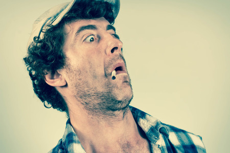 Shocked redneck jumps back in fear as he smokes his cigaretteの写真素材