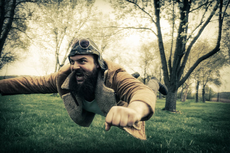 Bearded aviator soars through the air like an airplaneの写真素材