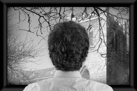 Back of man's head as he's watching flat screen televisionの写真素材