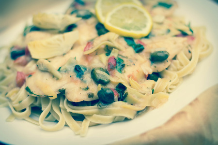 Italian chicken piccata schnitzel with artichoke hearts served on linguineの写真素材