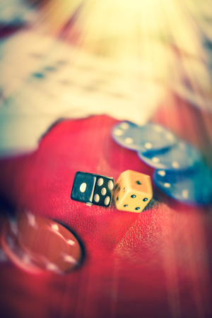 Rolling the dice in crowded gambling themed background, red for warning of addictionの写真素材