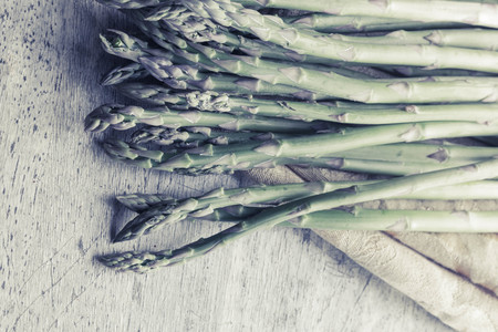 Fresh organic asparagus straight from the farmer's market on distressed table topの写真素材