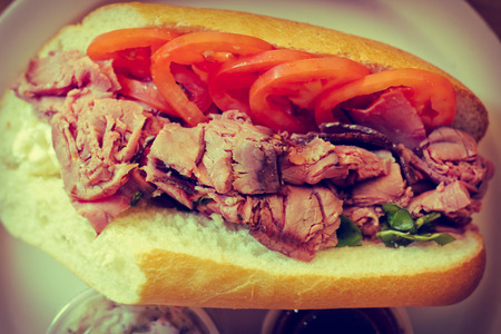 Roast beef on torpedo roll with tomato basil and fresh mozzarella cheeseの写真素材