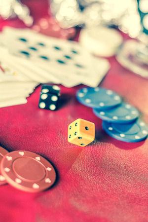 Rolling the dice in crowded gambling themed background, red for warning of addictionの写真素材