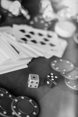 Rolling the dice in crowded gambling themed background, red for warning of addictionの写真素材