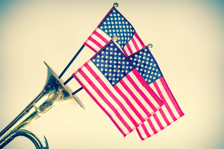 Three American Flags erupt from the bell of a trumpet in patriotism imageの写真素材