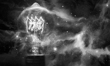 Edison style light bulbs against beautiful universe of stars and galaxiesの写真素材