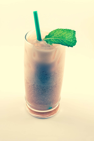 Refreshing thai iced tea garnished with fresh mint leaves