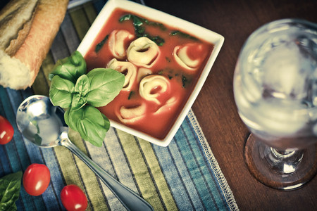 Hearty tortellini tomato soup with spinach and basilの写真素材