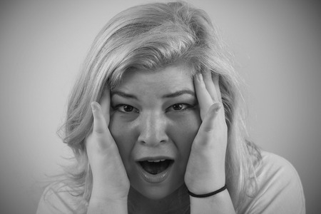 Cut girl is overwhelmed and grasps her faceの写真素材