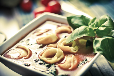 Hearty tortellini tomato soup with spinach and basilの写真素材