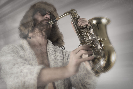 Bearded hipster plays jazz saxophone in leopard print bathrobeの写真素材