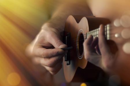 Closeup shirtless male musician playing soprano ukulele