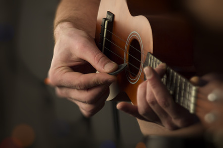 Closeup shirtless male musician playing soprano ukuleleの写真素材