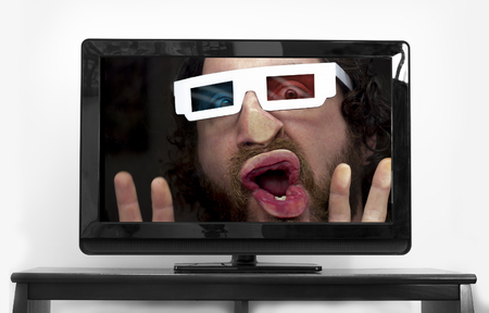 Silly bearded man wearing 3D glasses stuck inside TV screen