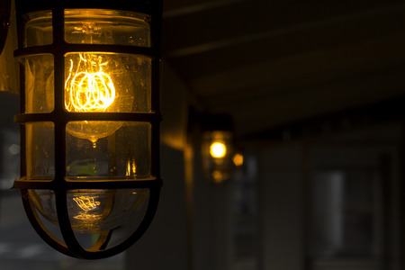 Decorative antique edison style filament light bulb outside at night