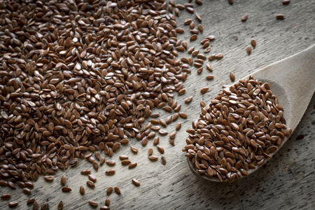 Close up flax seed on rustic worn wooden table surfaceの写真素材