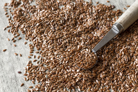Close up flax seed on rustic worn wooden table surfaceの写真素材
