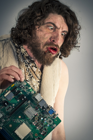 Silly grunting caveman confused by modern computer technologyの写真素材