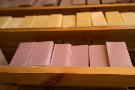 Rows of colorful homemade bar soap on wooden tableの写真素材