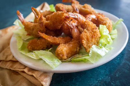 Large serving of popcorn shrimp tempura appetizer on bed of lettuceの写真素材