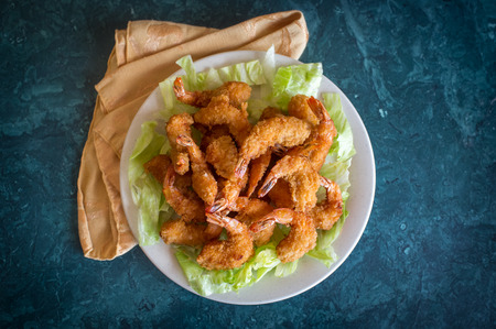 Large serving of popcorn shrimp tempura appetizer on bed of lettuce