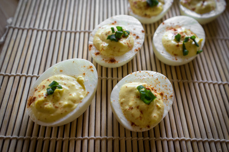 Stuffed Russian deviled eggs topped with chives and paprika