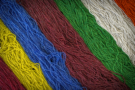 Background rainbow of colorful beaded necklaces and braceletsの写真素材