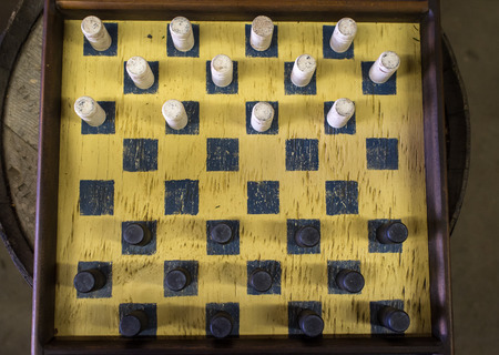 Rugged old dirty antique checkers board and piecesの写真素材