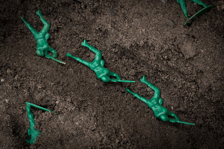 Green toy soldiers in the dirt defending the trenchesの写真素材