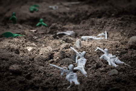 Green toy soldiers in the dirt defending the trenches