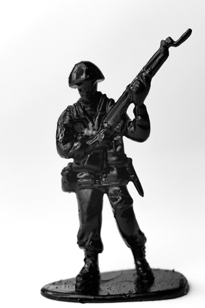 Dramatic toy army soldier carrying rifle to battle in black and white imageの写真素材