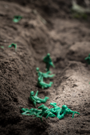 Green toy soldiers in the dirt defending the trenchesの写真素材