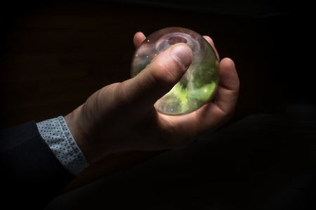 Holding the universe in fortune teller magic crystal ballの写真素材