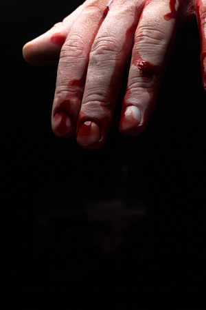 Bloody hands emerge from the darkness in horror Halloween imageの写真素材
