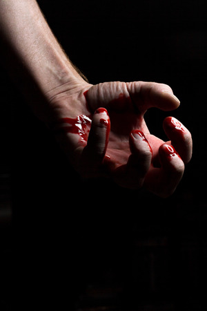 Bloody hands emerge from the darkness in horror Halloween imageの写真素材