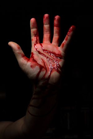 Bloody hands emerge from the darkness in horror Halloween imageの写真素材