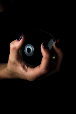 Female hands hold crystal ball for fortune telling backgroundの写真素材