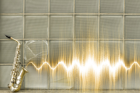 Jazz saxophone with sound wave by glass windowsの写真素材
