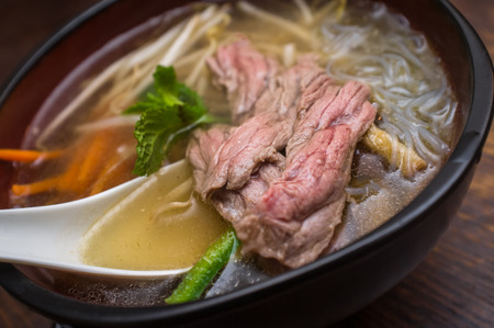 Traditional Vietnamese pho beef noodle soup garnished with mint leaves