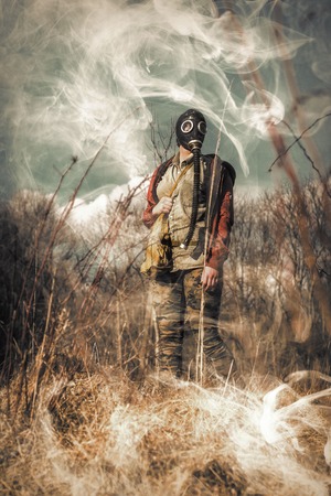 Scary girl wearing authentic Russian gas mask in billowing toxic smokeの写真素材