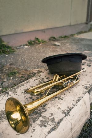 Old worn trumpet against grungy wall with pork pie style top hatの写真素材