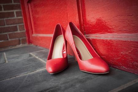 Red high heel shoes on street outdoors with nobody wearing themの写真素材