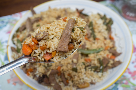 Steak and vegetable rice pilaf with serving spoonの写真素材